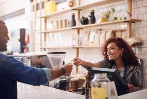 Girl in a cafe taking payment from a customer