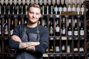 young male sommelier working in a wine cellar or bar