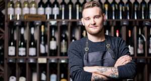 young male sommelier working in a wine cellar or bar
