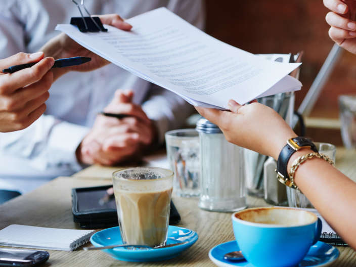 Lawyer handing over legal document at a meeting in a cafe