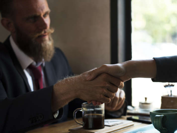 Business agreement handshake at coffee shop